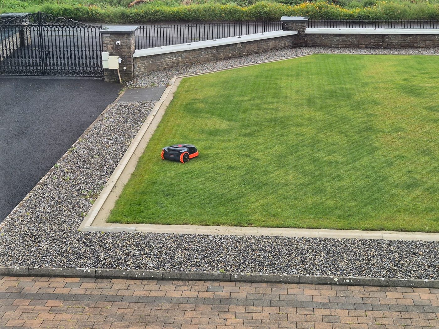 Manicured lawn with gravel surround and wall