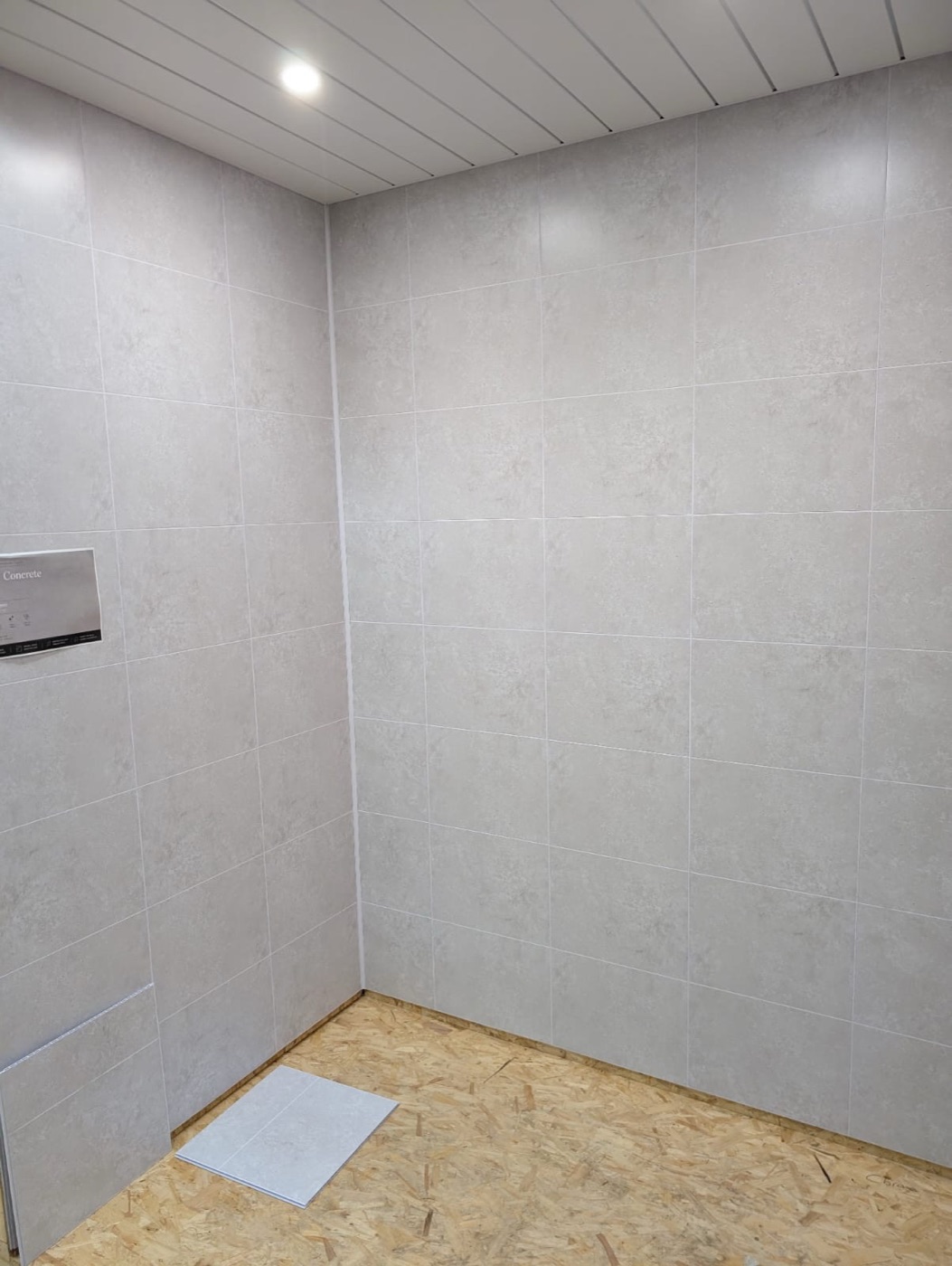 Concrete-effect wall panels with panelled ceiling in a shower area